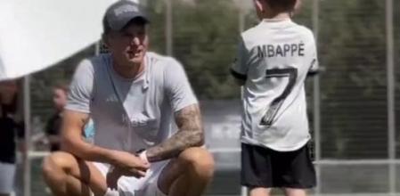 Kroos, hablando con niño con la camiseta de Mbappé