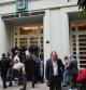 Journalists gather outside the Argentine Soccer Association (AFA) headquarters being raided as part of a judicial investigation into links authorities allege AFA has with a financial services company being investigated for alleged money laundering in Buenos Aires, Argentina, Tuesday, Dec. 9, 2025. (AP Photo/Rodrigo Abd)